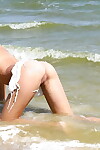 Slender fresh juvenile with smooth on top wet crack posing unclothed on the beach