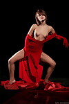 Sultry erotic exhibit in red fancy costume posing seductively with miniscule milk shakes bared