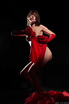Sultry erotic exhibit in red fancy costume posing seductively with miniscule milk shakes bared