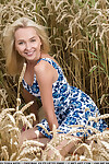 Teen blond Bernie removes her short clothing to pose nude in the wheat field