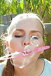 Good infant Dominika blows soap bubbles prior to showcasing her shaved fur pie in marsh