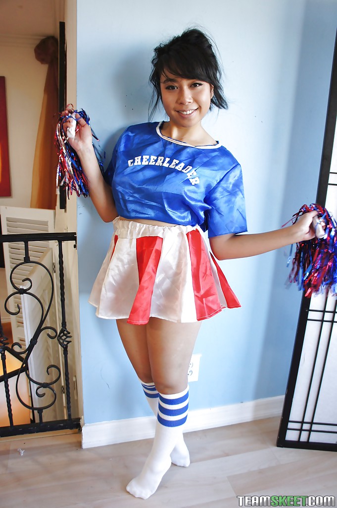 Petite Oriental cheerleader May Lee flashing black panties under skirt