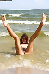 Slender fresh juvenile with smooth on top wet crack posing unclothed on the beach