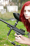 Glamorous juvenile redhead Piper posing in nature\'s garb with a paintball gun