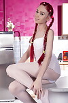 Thin infant doll flaunts her stripped body with her red hair in braided pigtails