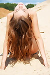 Juvenile year old doll way fully undressed on a deserted sandy beach