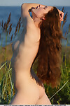 Untamed redhead Nicole K suns her smooth on top vagina nude at the beach