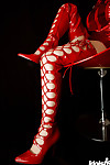 Pleasant oriental adolescent lass in high heeled boots uncovering her attractive curves